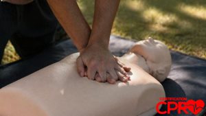 Person performing hands-only CPR on a mannequin outdoors in Clearwater.