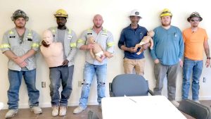 Group of trainees practicing CPR techniques with mannequins.