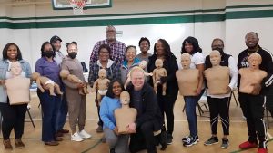 Group of people practicing CPR on mannequins during onsite training.